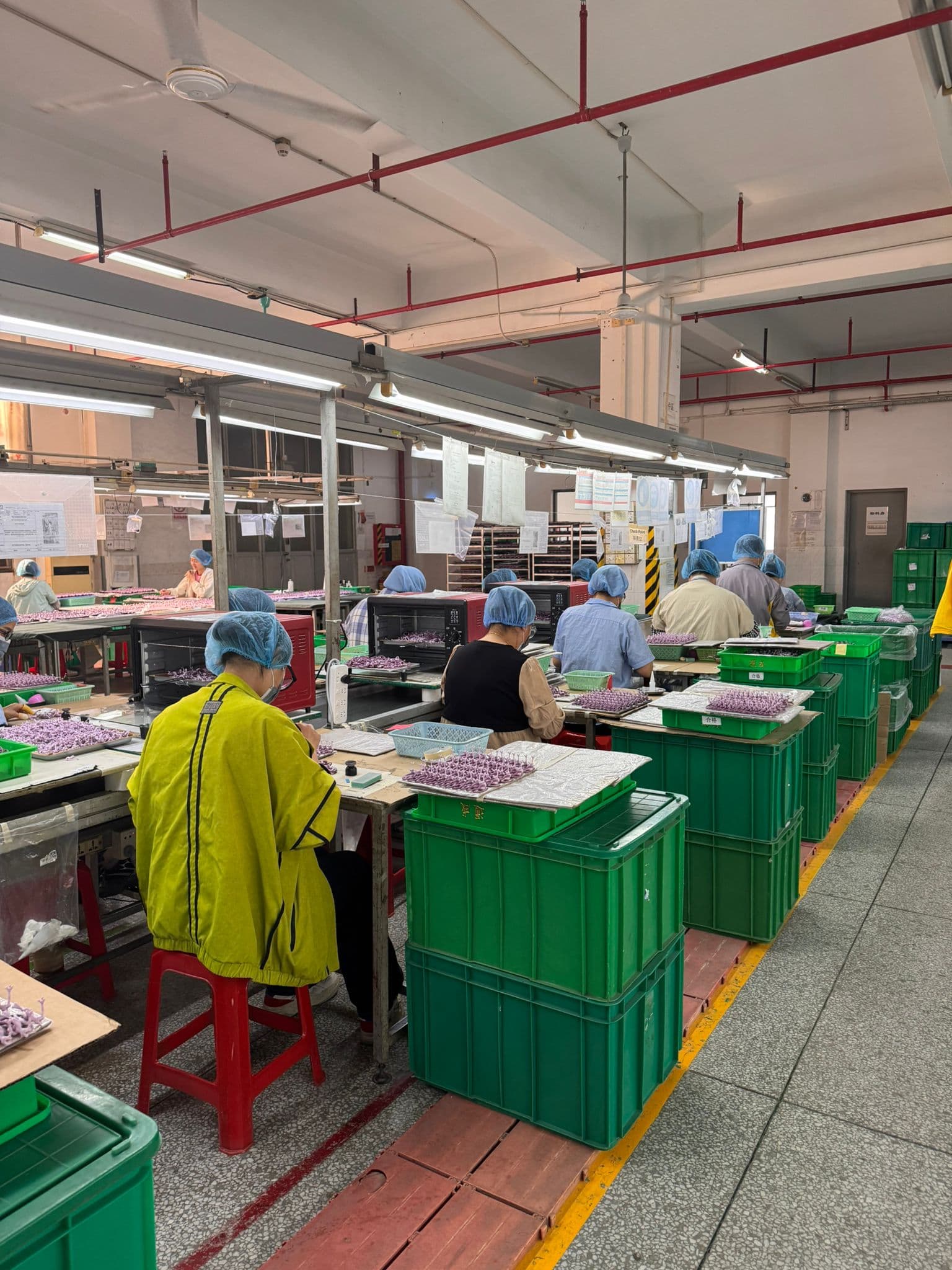 工人在配備檢查燈的裝配工位上作業