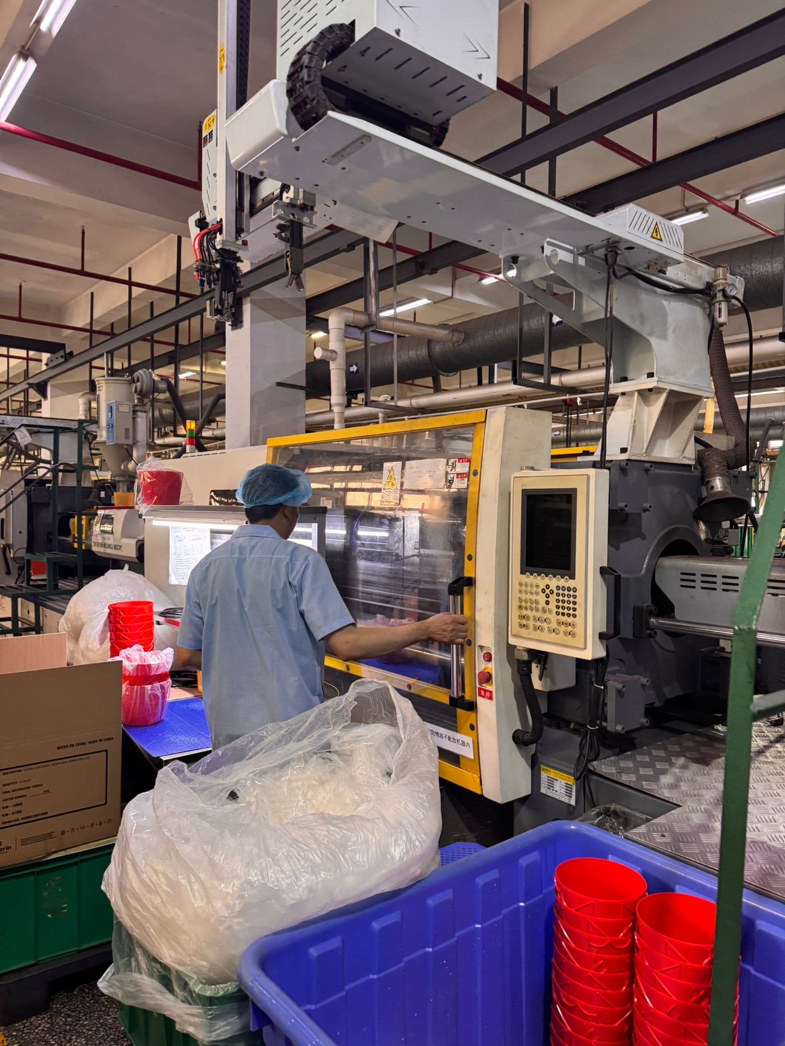 操作員配合自動夾取機械臂工作